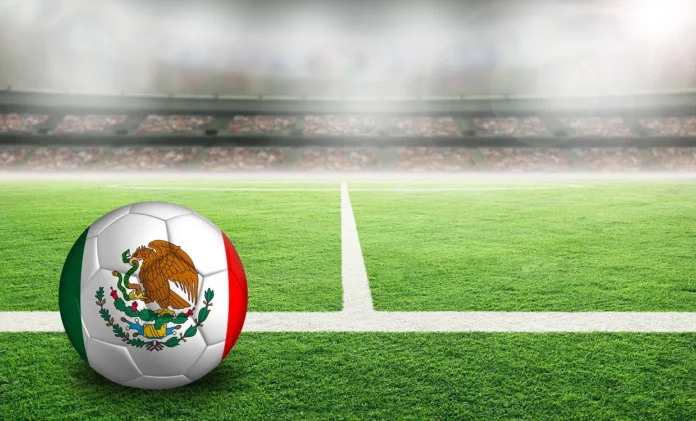 Balón con la bandera de México en un campo de fútbol.
