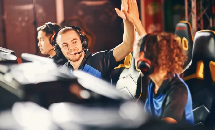Vista lateral de jugadores compitiendo en un torneo internacional de esports con público y luces de escenario.