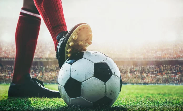 Futbolista con un balón de fútbol en una cancha
