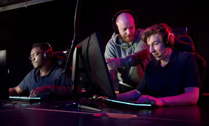 Joven jugador de esports escuchando a su compañero de equipo en medio de una partida competitiva.