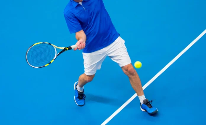 Hombre jugando tenis en cancha dura
